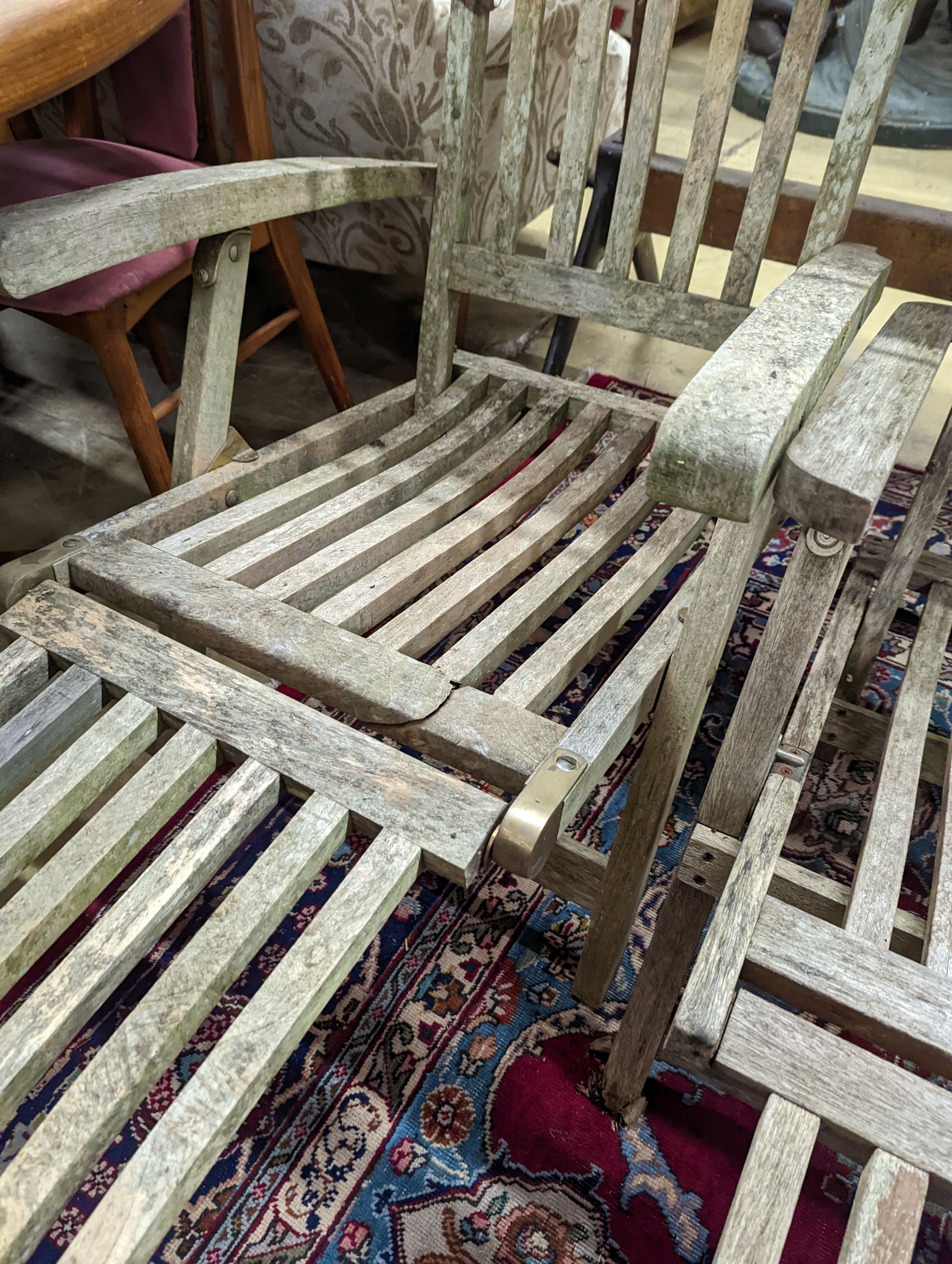 Two weathered teak garden steamer chairs. Heights for both chairs, 102cm and 88cm.